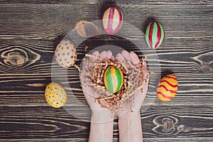 Hands holding modern painted easter egg