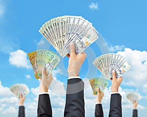 Hands holding money in multi currencies - money raising, funding