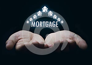 Hands holding Mortgage word with houses.