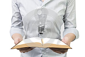 Hands holding open book with light bulb