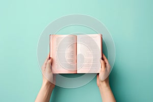 Hands holding an open book on pastel background. Reading, studying, school, diary, education, university learning, time for