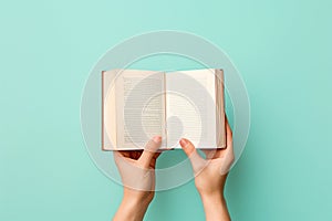 Hands holding an open book on pastel background. Reading, studying, school, diary, education, university learning, time for