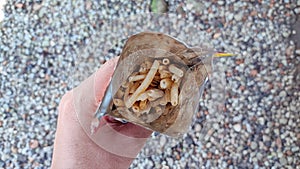 Hands are holding an open packet of snacks