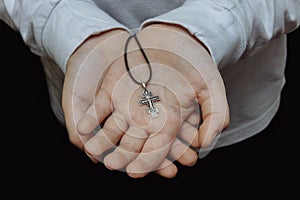 Hands holding an Orthodox cross close-up photo