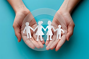 Hands holding paper cut outs of family