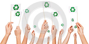 Hands holding paper flags with recycle symbol