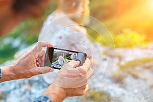 Hands holding the phone and taking pictures of the girl on the phone