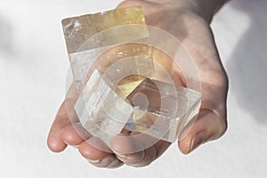 Hands holding piece of Optical Calcite