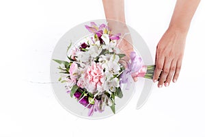 Hands holding a pink bouquet from gillyflowers and alstroemeria