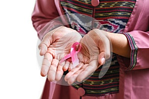 Hands holding pink ribbon, breast cancer awareness, October pink concept