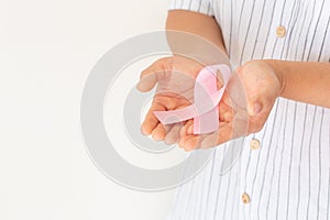 Hands holding pink ribbon curl on white isolated background with copy space. Breast cancer Awareness, male breast cancer disease,