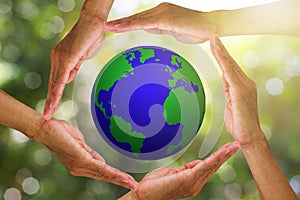 Hands holding planet earth on blurred green bokeh nature with warm sunlight background