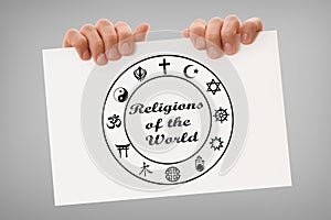 Hands holding poster with symbols of religions and cultural diversity photo