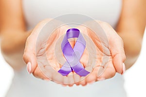 Hands holding purple awareness ribbon
