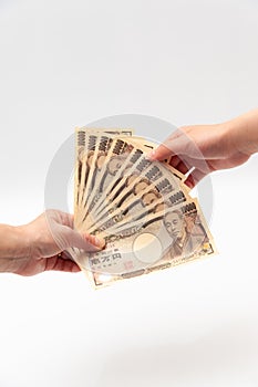 Hands holding receiving / paying 100,000 yen.  on white background.