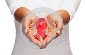 Hands holding red AIDS awareness ribbon