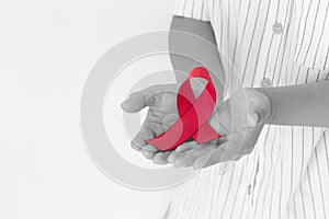 Hands holding Red burgundy ribbon bow on white background with copy space, symbol of Multiple Myeloma or Plasma cell cancer