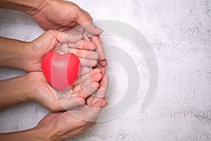 Hands holding a red heart, CSR or Corporate Social Responsibility, health care, family insurance, heart donate concept