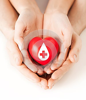 Hands holding red heart with donor sign