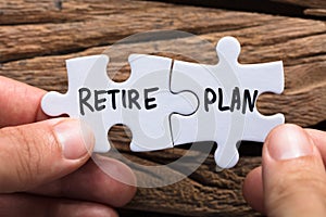 Hands Holding Retire Plan Matching Jigsaw Pieces