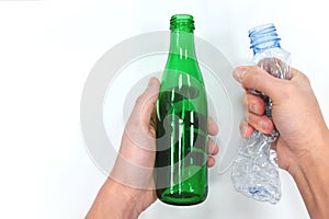 Hands holding reusable glass bottle and plastic bottle in white background. Reduce reuse recycle