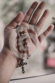 Hands are holding Rosary beads