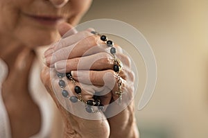 Hands holding rosary and praying