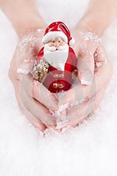 Hands holding santa claus - concept for christmas with nails