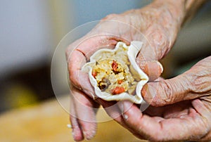 Hands Holding Shaomai Chinese Rice Dumpling Wrapper Filled with Sticky Rice & Pork