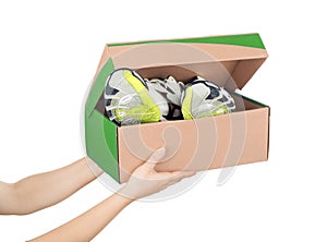 Hands holding shoes in a box