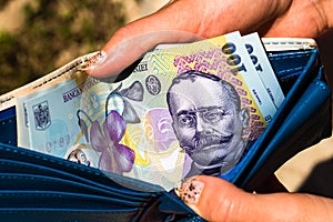 Hands holding and showing wallet with romanian money LEI