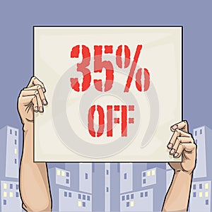 Hands holding a sign card that says 35% off sale