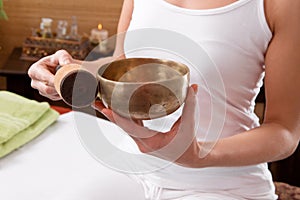 Hands holding singing bowl prepared for meditation