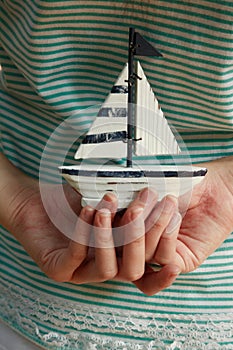 Hands holding small saiboat