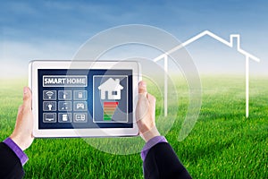 Hands holding smart house controller at field