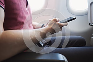 Hands holding smart phone in airplane