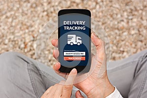 Hands holding smart phone with delivery tracking concept on screen