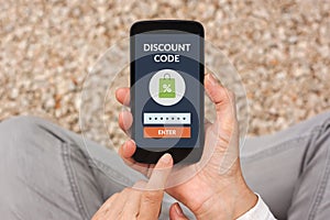 Hands holding smart phone with discount code concept on screen