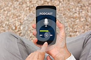 Hands holding smart phone with podcast concept on screen