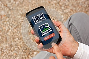 Hands holding smart phone with SEO concept on screen