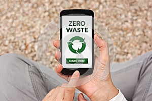 Hands holding smart phone with zero waste concept on screen