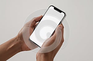 Hands holding a smartphone with a blank white screen.