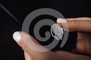 Hands holding smartphone with fingerprint scanner in the screen.