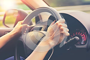 Hands holding on steering wheel while driving