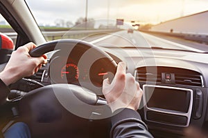 Hands holding on steering wheel while driving