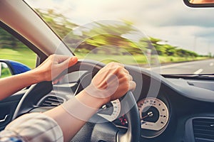 Hands holding on steering wheel while driving