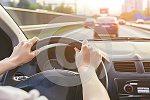 Hands holding on steering wheel while driving