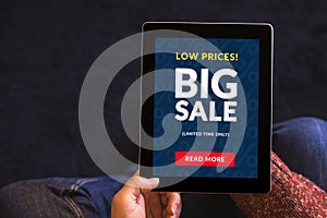 Hands holding tablet computer with big sale concept on screen