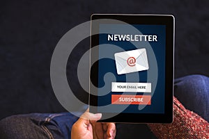 Hands holding tablet computer with subscribe newsletter concept