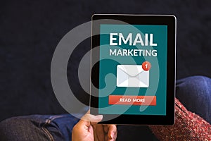 Hands holding tablet with email marketing concept on screen